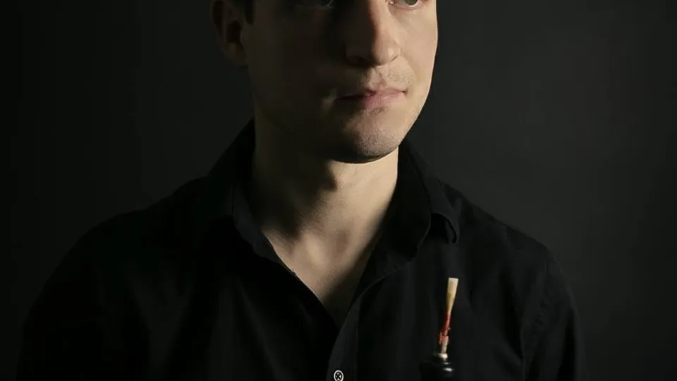 The image shows Theophile Hartz in front of a black wall, indoors