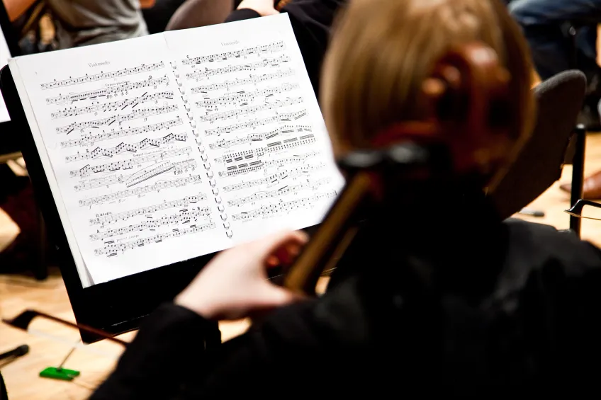 Student playing the cello. Photo.