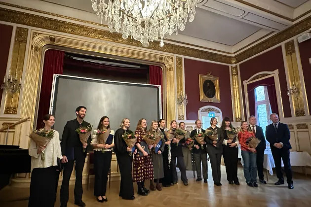 Personer på rad tar emot ett stipendium. Foto.