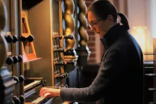Bine Bryndorf spelar på en orgel. Foto.